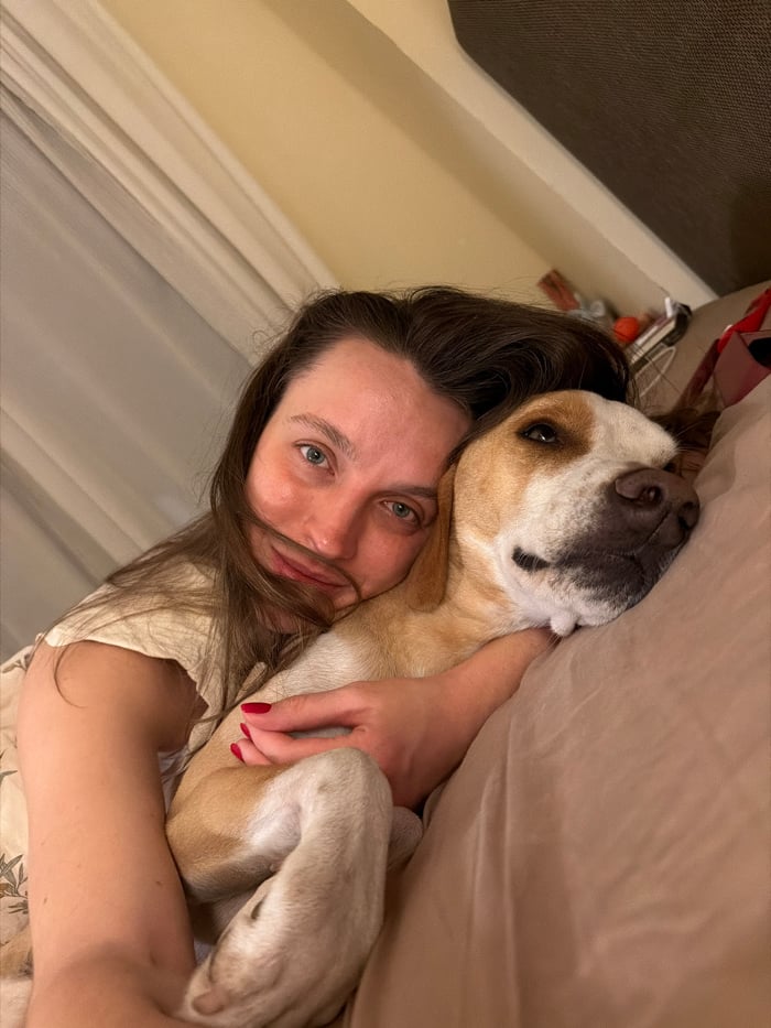 Woman and dog share quiet bedroom moment in Budva