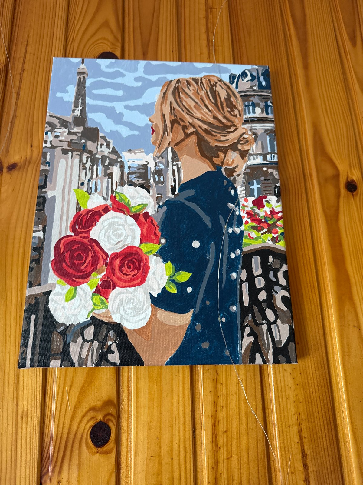 Three mounted artworks observed on wooden panel walls