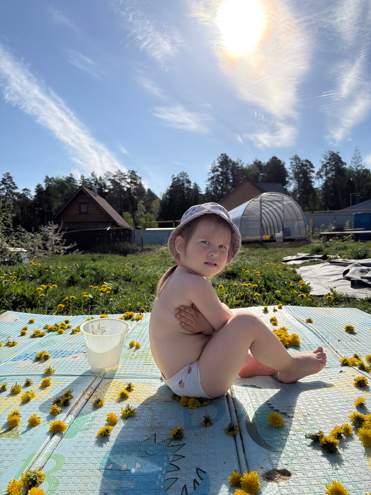 Family creates dandelion art on play mat in Chaikovsky