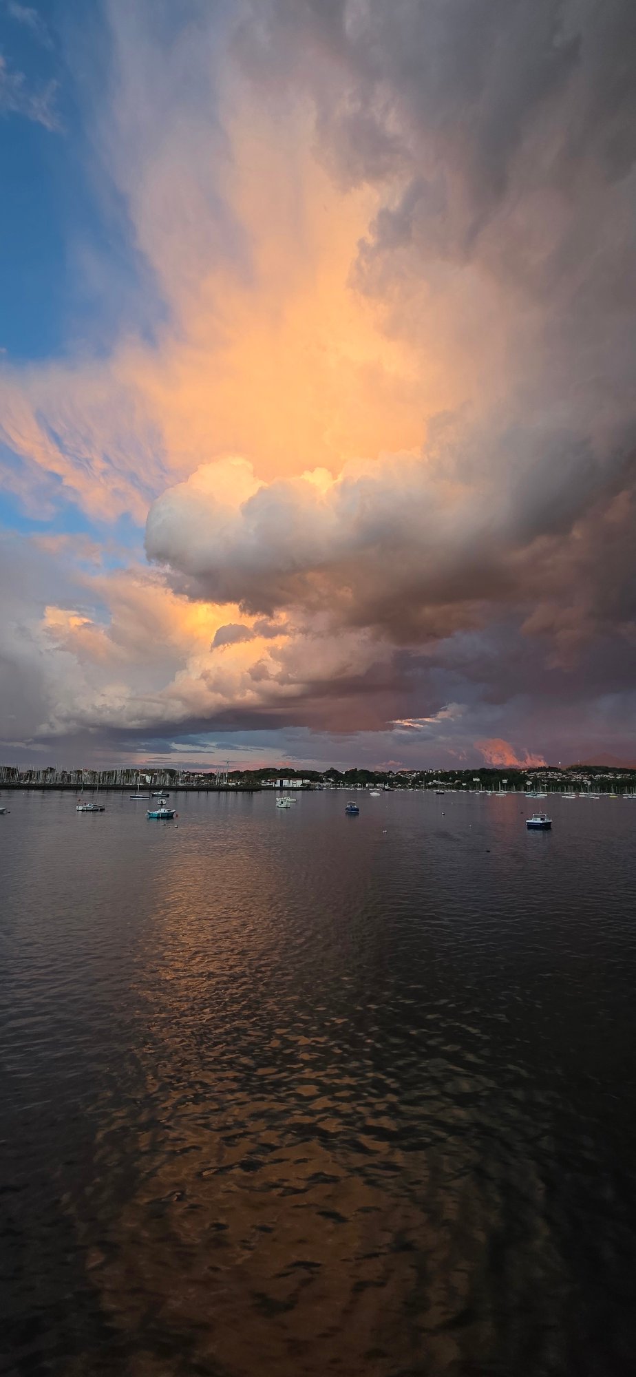 Dramatic sunset captured over Hondarribia waterfront amid storm clouds