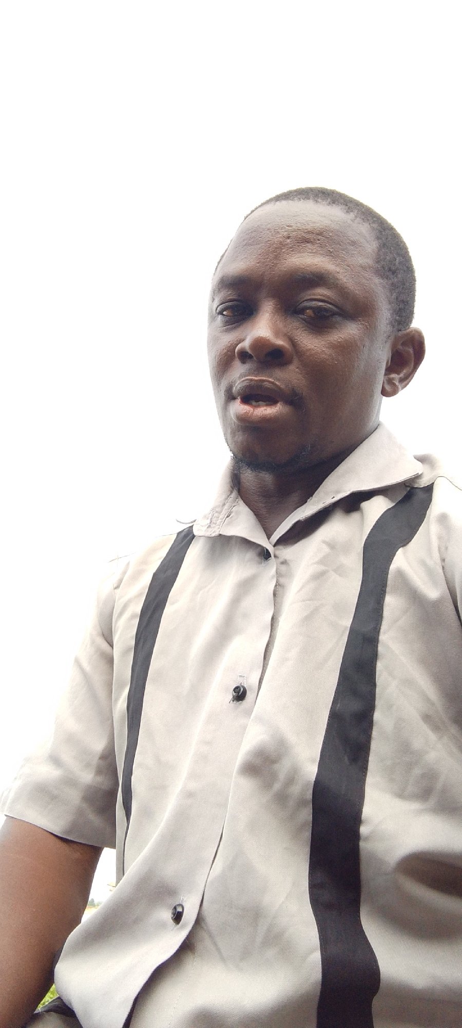 Man cooking outdoors in industrial area, Lokoja Nigeria