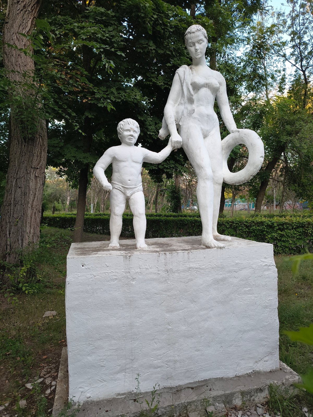 Evening at Mikhaylovka's riverside park — sculptures, beach, and promenade