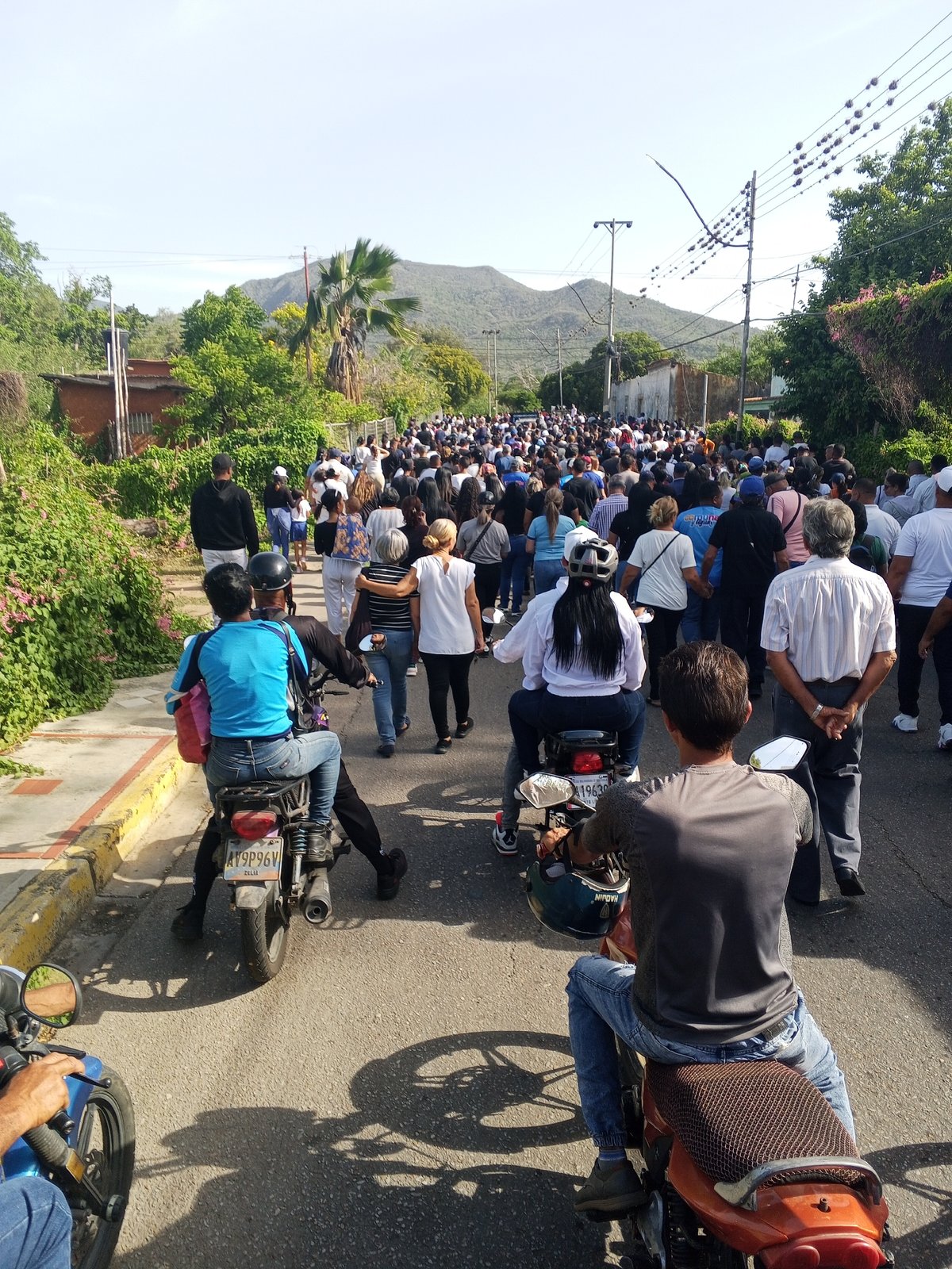 Street procession with motorcycles and crowd in Santa Ana, Venezuela
