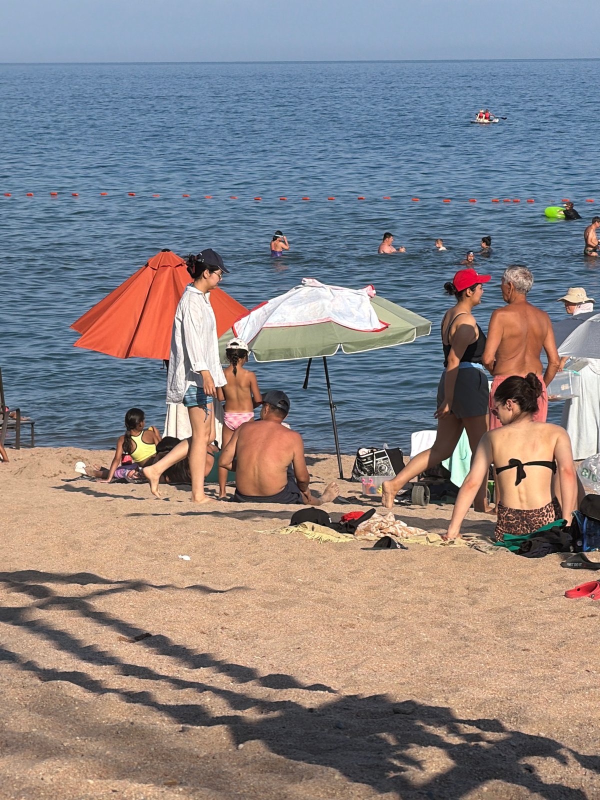 Sunny beach day with paddleboarding, swimming, and lounging