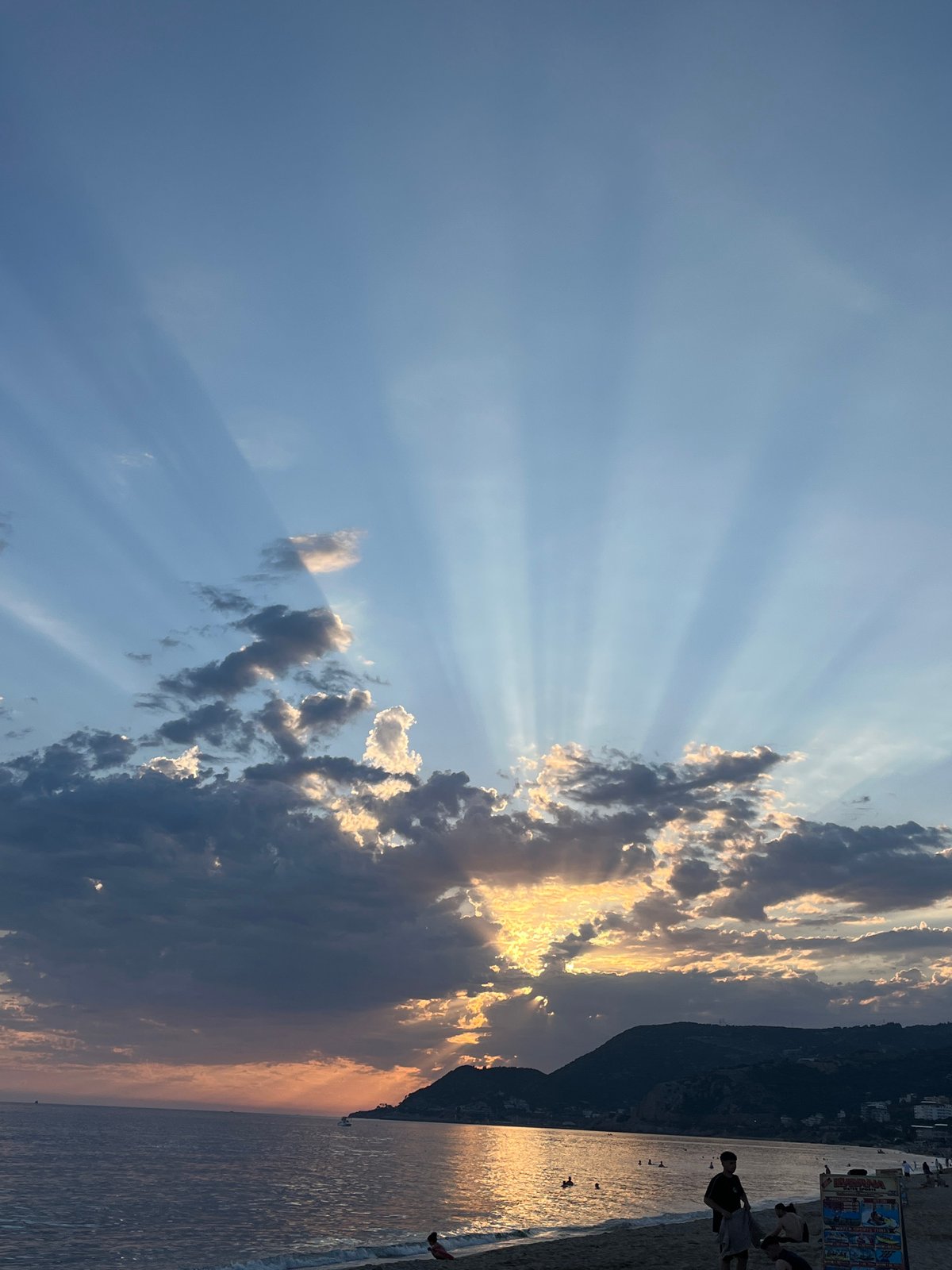 Evening beach activities observed during dramatic sunset in Alanya