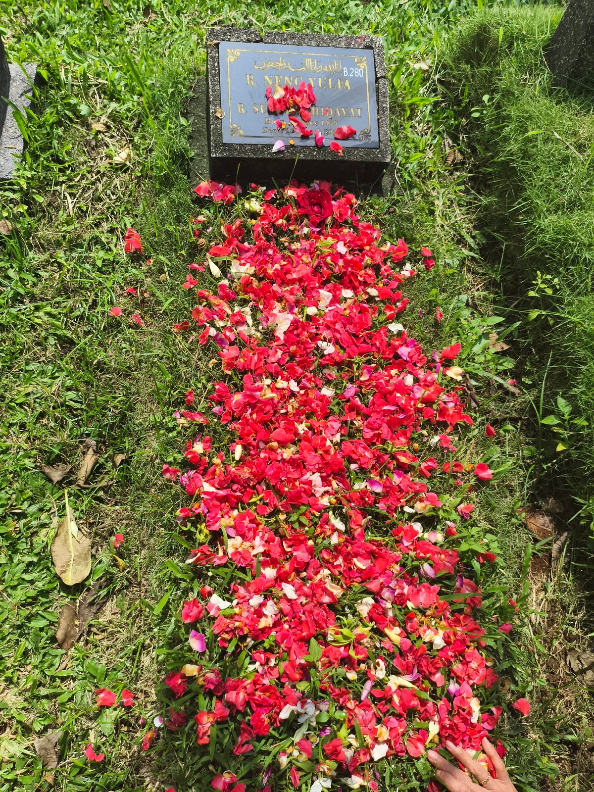 Woman visits grave at Depok cemetery during early morning hours