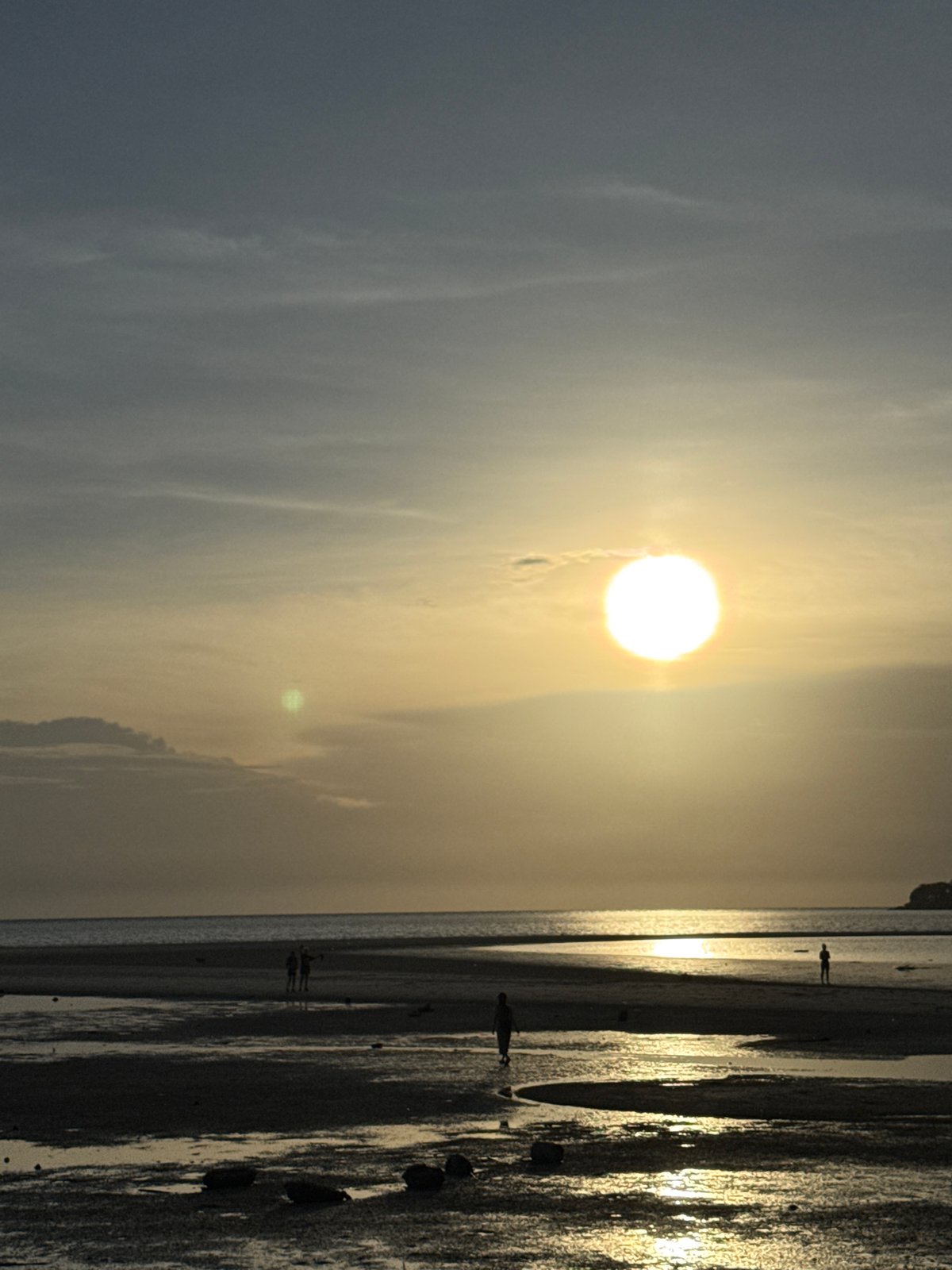 Sunset strollers and dogs enjoy peaceful evening on Koh Phangan beach