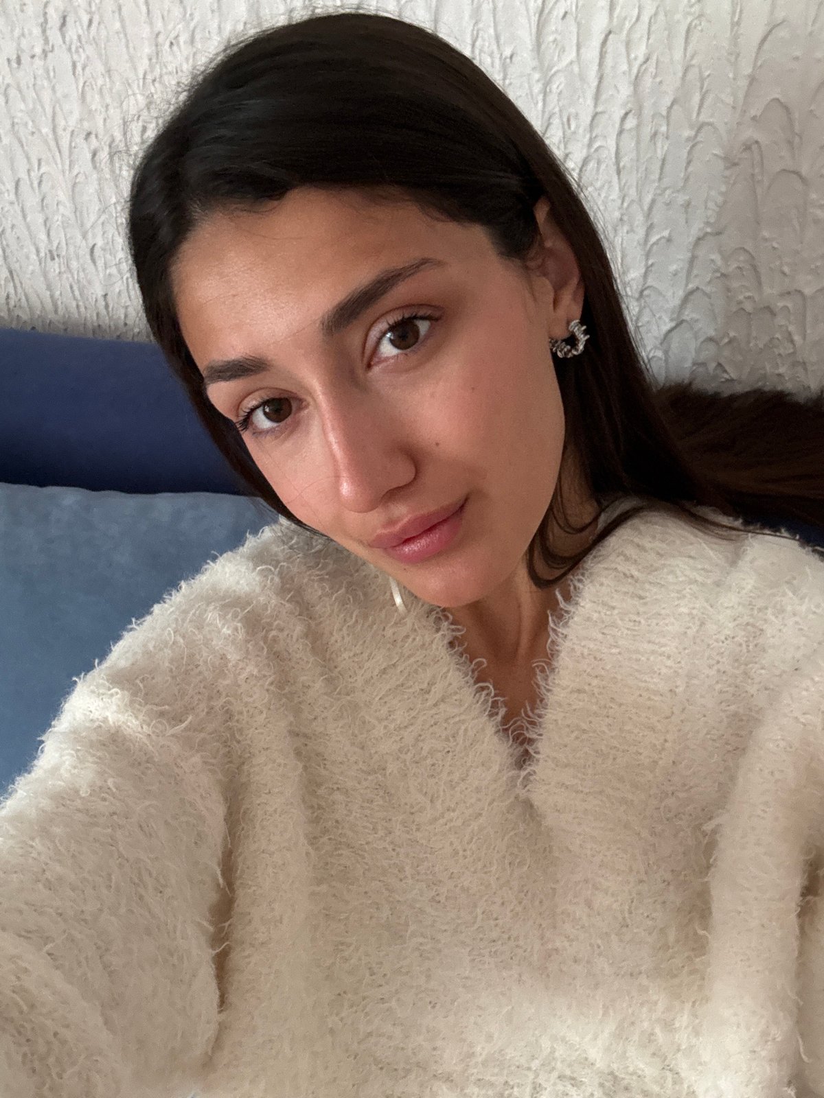 Woman in sweater resting on white surface in Montenegro