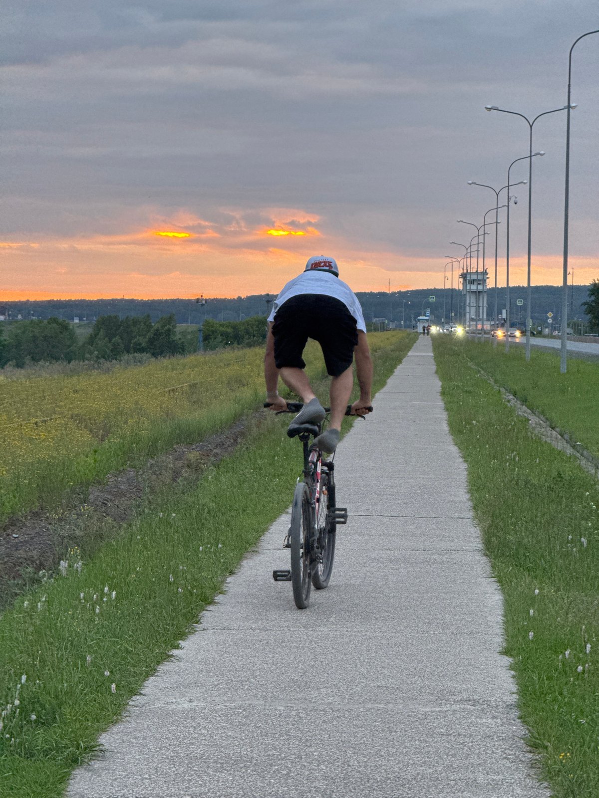 Cyclist performs stunts on path near railroad tracks in Chaikovsky