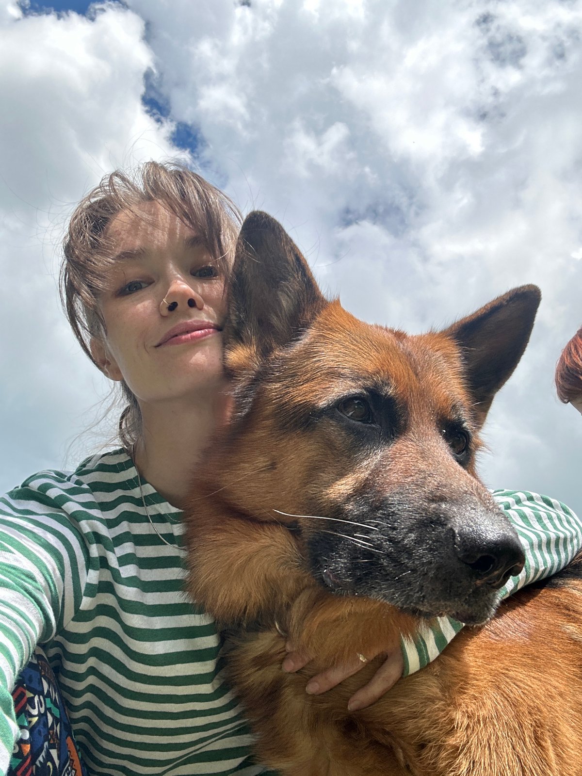 Backyard day with a German Shepherd, BBQ, and blue skies.