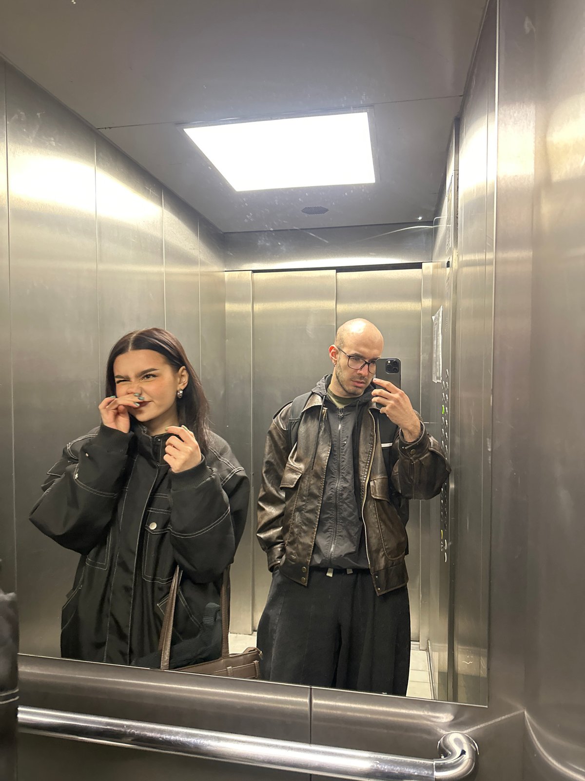 Two people observed in Moscow elevator, man in reflection