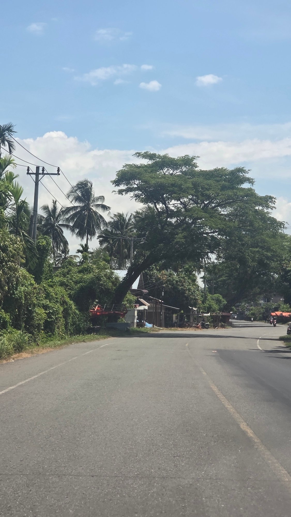 Car with open trunk, three people observed roadside Indonesia