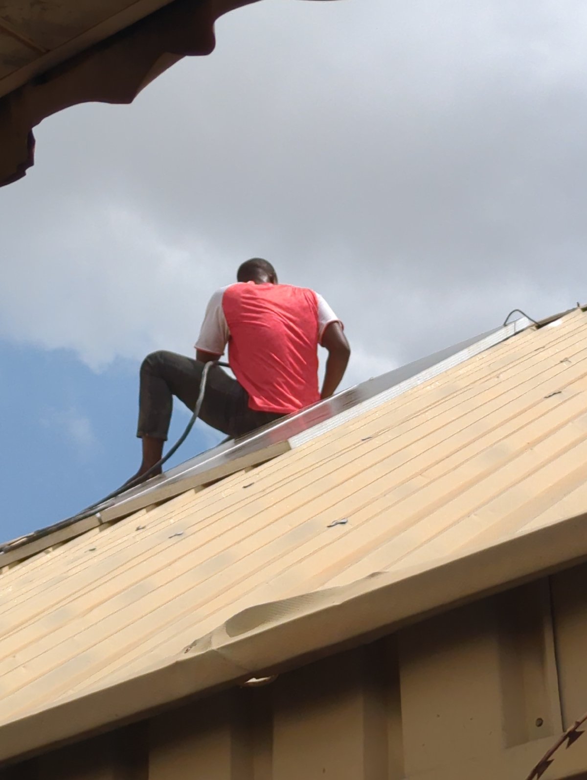 Person climbs ladder against building in Sabon Tasha