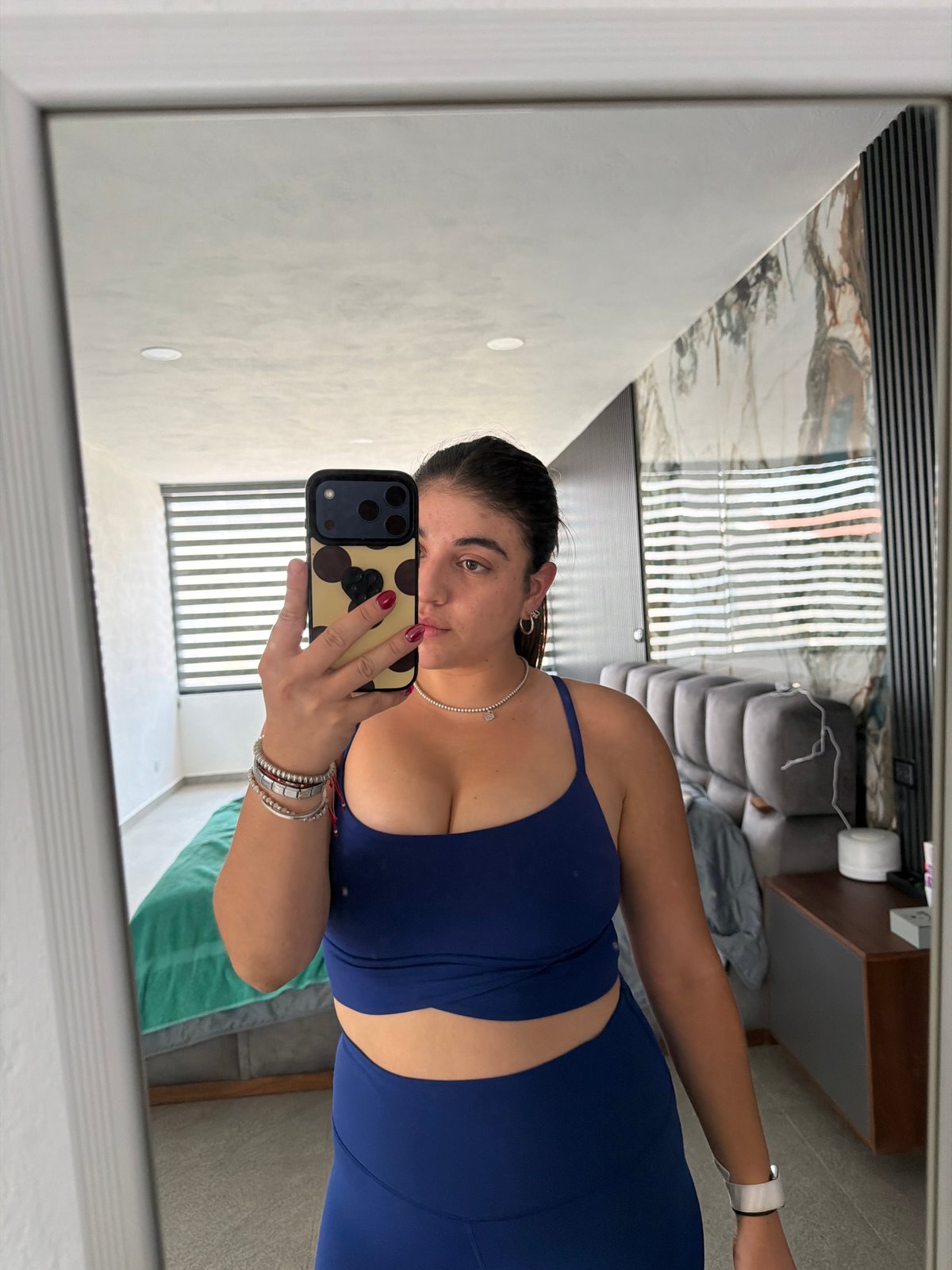 Woman documents evening routine with selfies, pet in Puebla bedroom