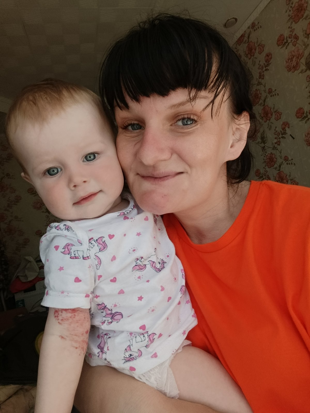 Mother tends baby during morning routine in Russian village