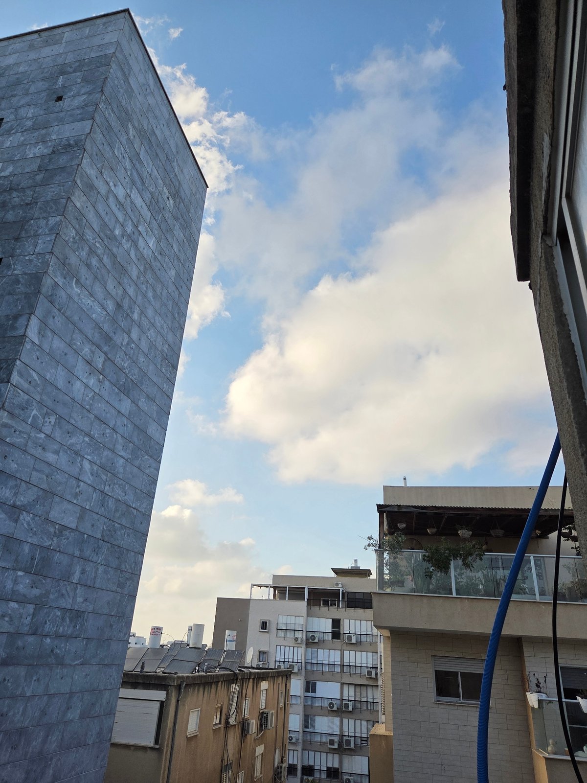 Street-level buildings and a YouTube browse session in Rishon LeZion