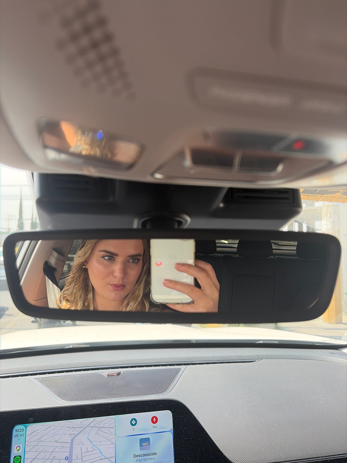 Woman takes selfie in car passenger seat in Puebla