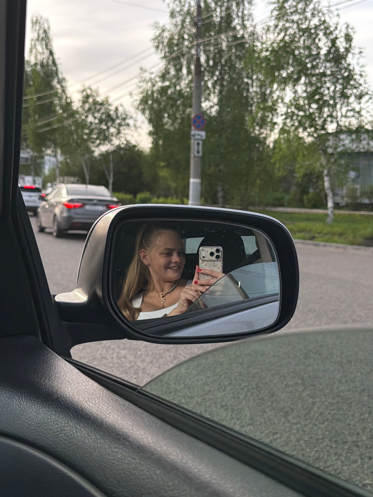 Woman takes car mirror selfies in Izhevsk