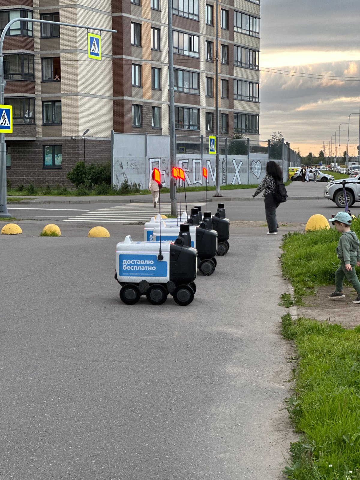 Autonomous delivery robots lined up outside a Sinyavino apartment block