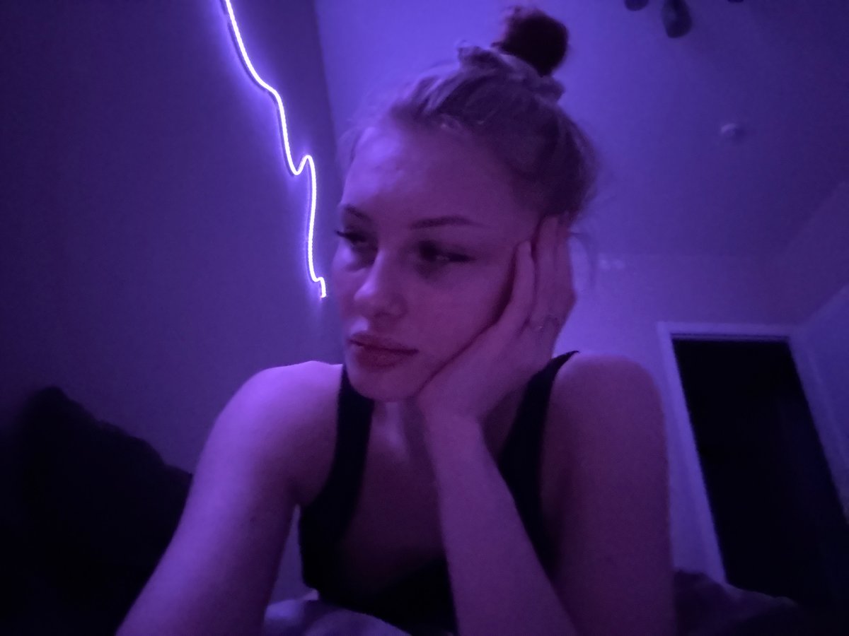 Woman photographed in purple light near window in Perm