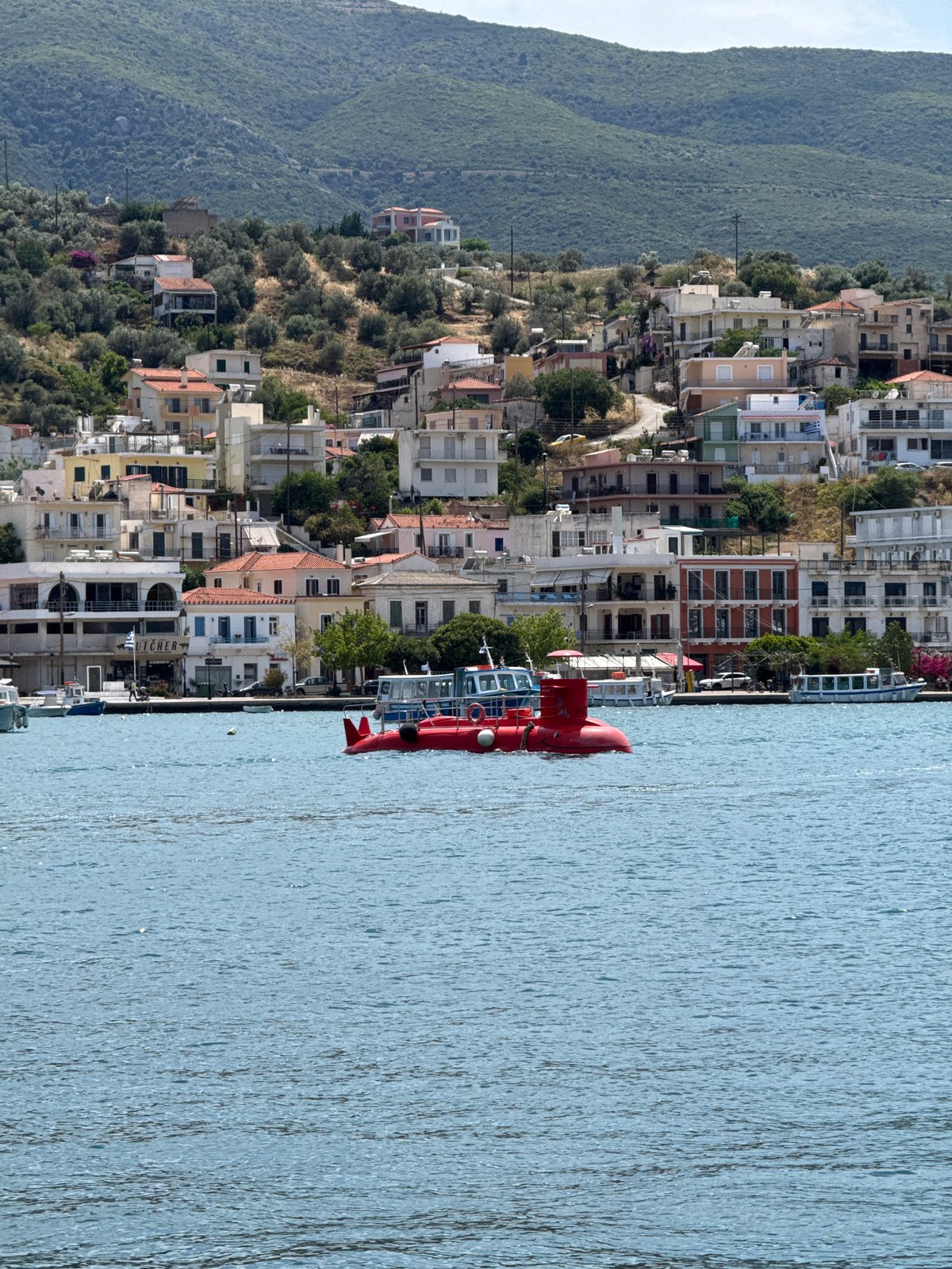 Tourists and locals enjoy typical morning activities in Poros, Greece