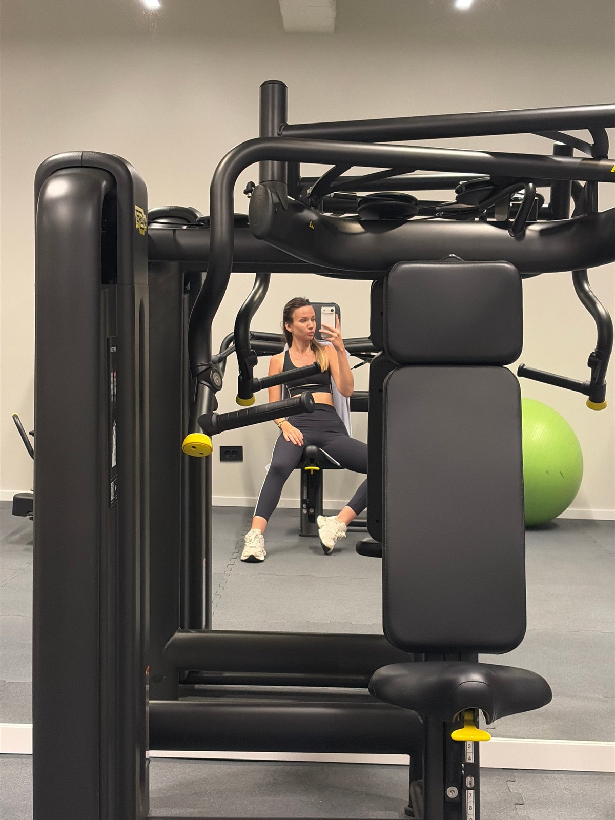 Woman documents gym session with smartphone selfies