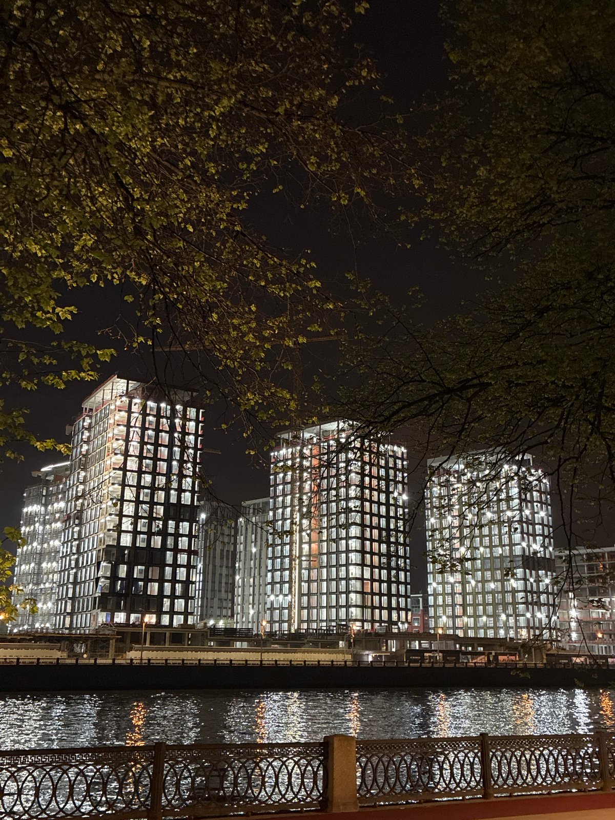 Illuminated Moscow buildings reflect in water at night