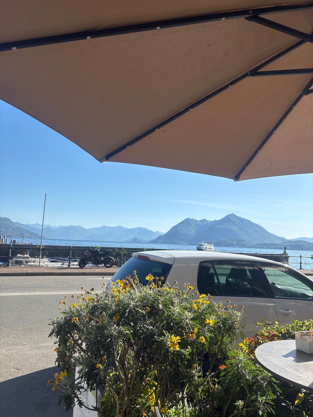 Woman enjoys breakfast at lakeside cafe in Binda, Italy