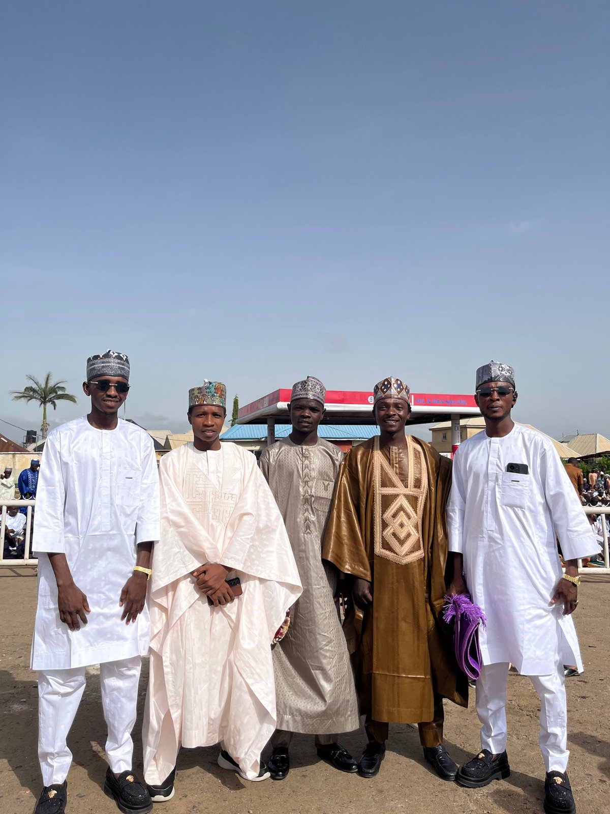 Men in traditional dress gather for photos outdoors