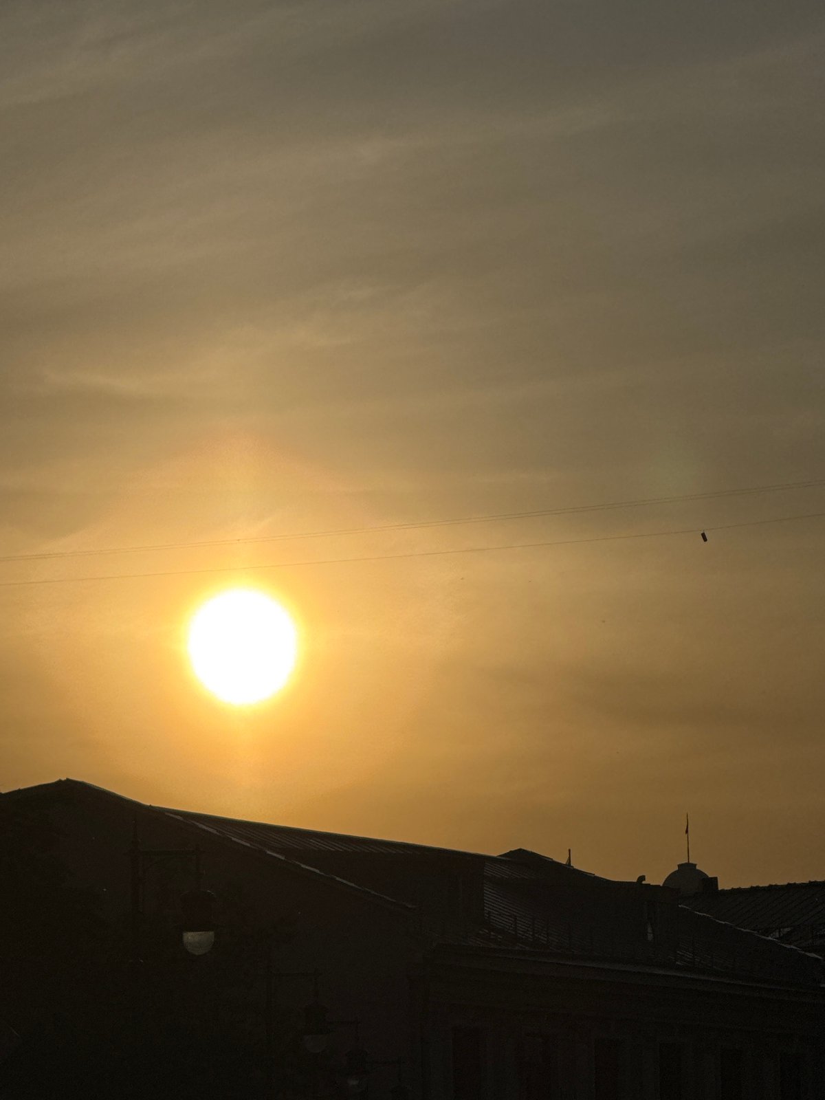 Golden sunset observed through power lines in Moscow