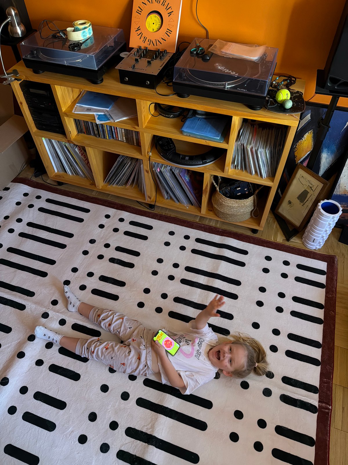 Woman unfolds patterned mat for child in Khimki home