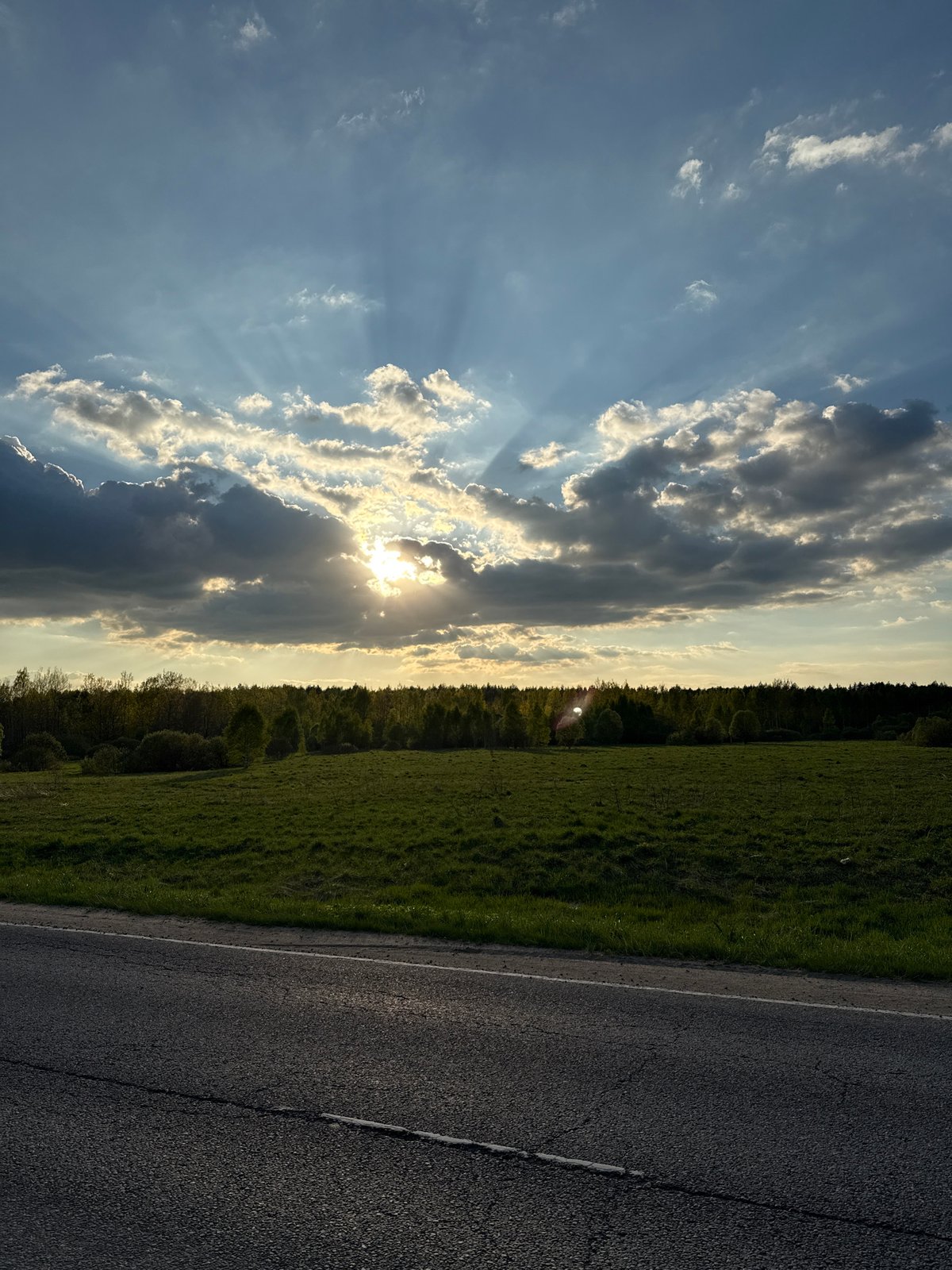 Sunlight breaks through clouds over rural Russian landscape