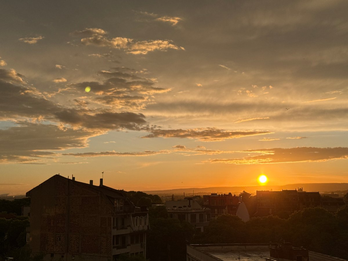 Cat watches sunset over Varna, Bulgaria from window perch