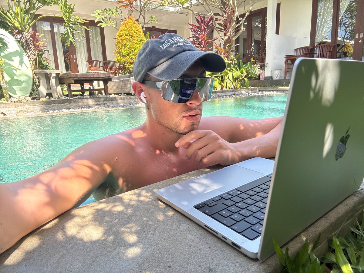 Man works on laptop poolside in North Kuta resort