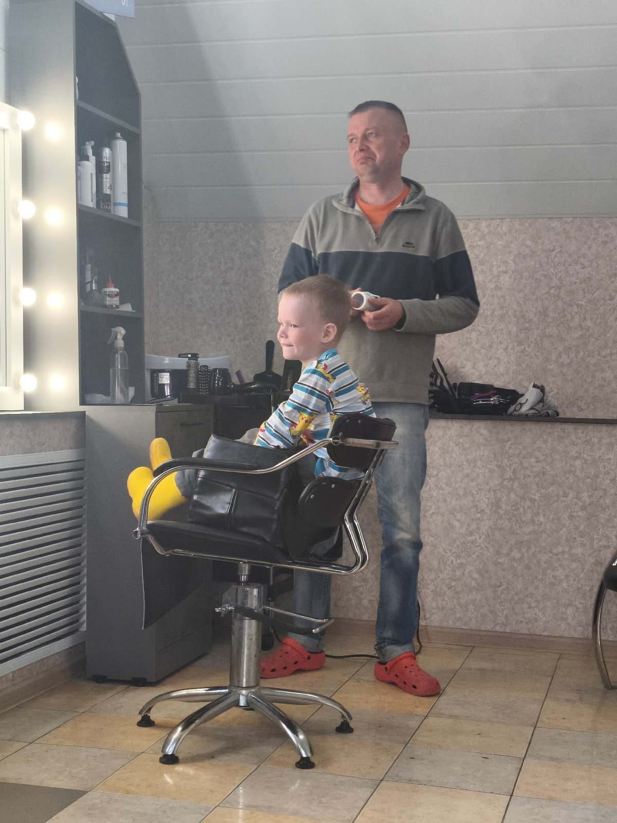 Boy receives haircut at Russian salon