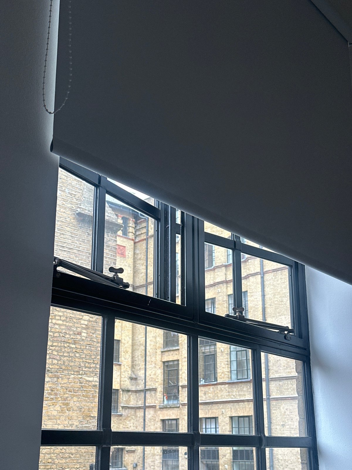London resident views brick building through apartment window