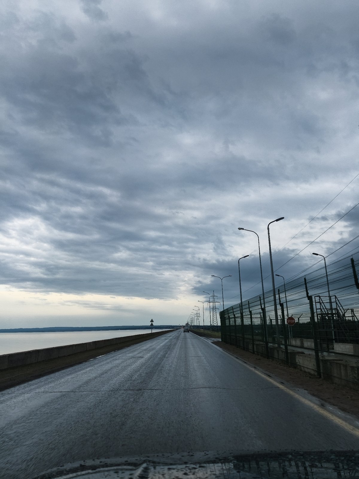 Wet road documented under cloudy skies near Noviy, Russia