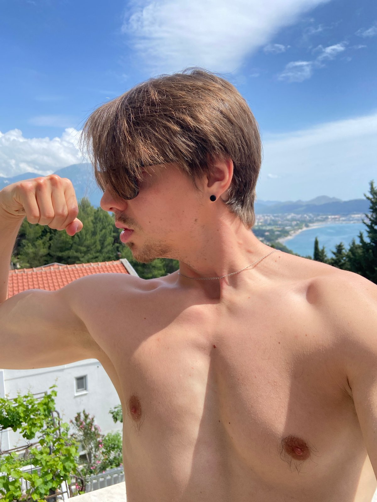 Man flexes overlooking Adriatic coastline in Šušanj, Montenegro