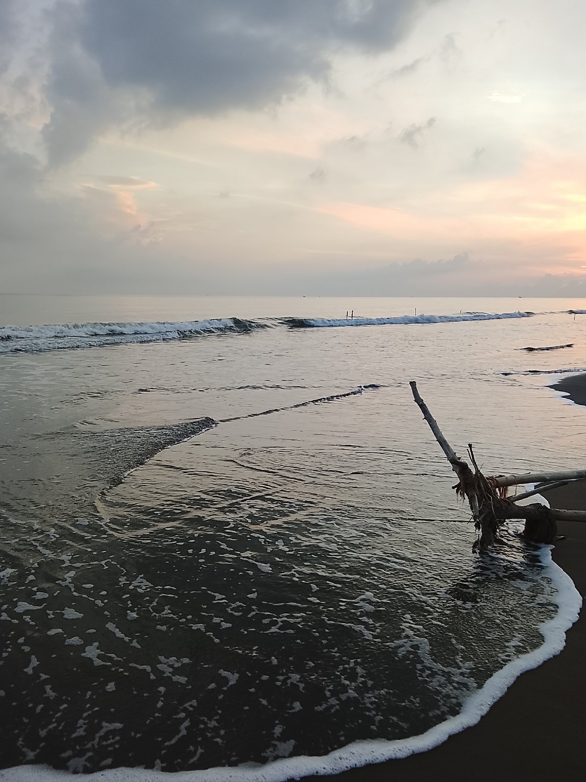 Quiet beach in Reudeuep at golden hour, gazebos and swings