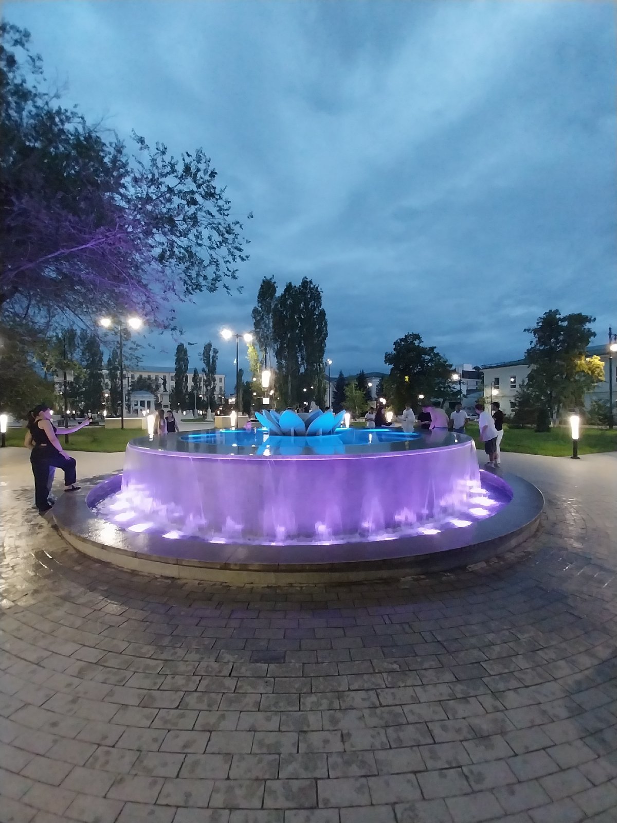 Orenburg fountain square glows at dusk on a summer evening