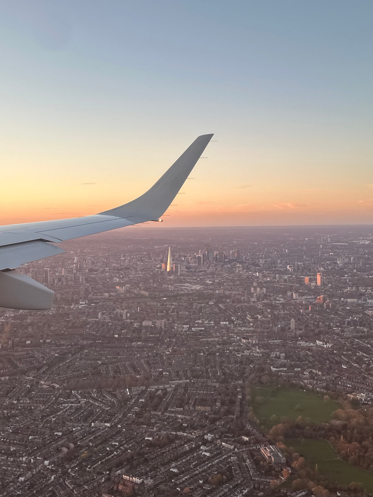 Aircraft captures aerial view of London cityscape at sunset