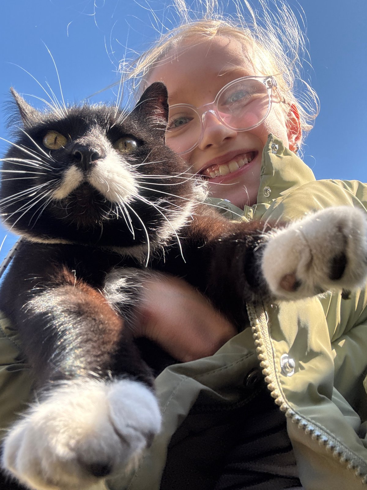 Person photographs with black and white cat in Riga park