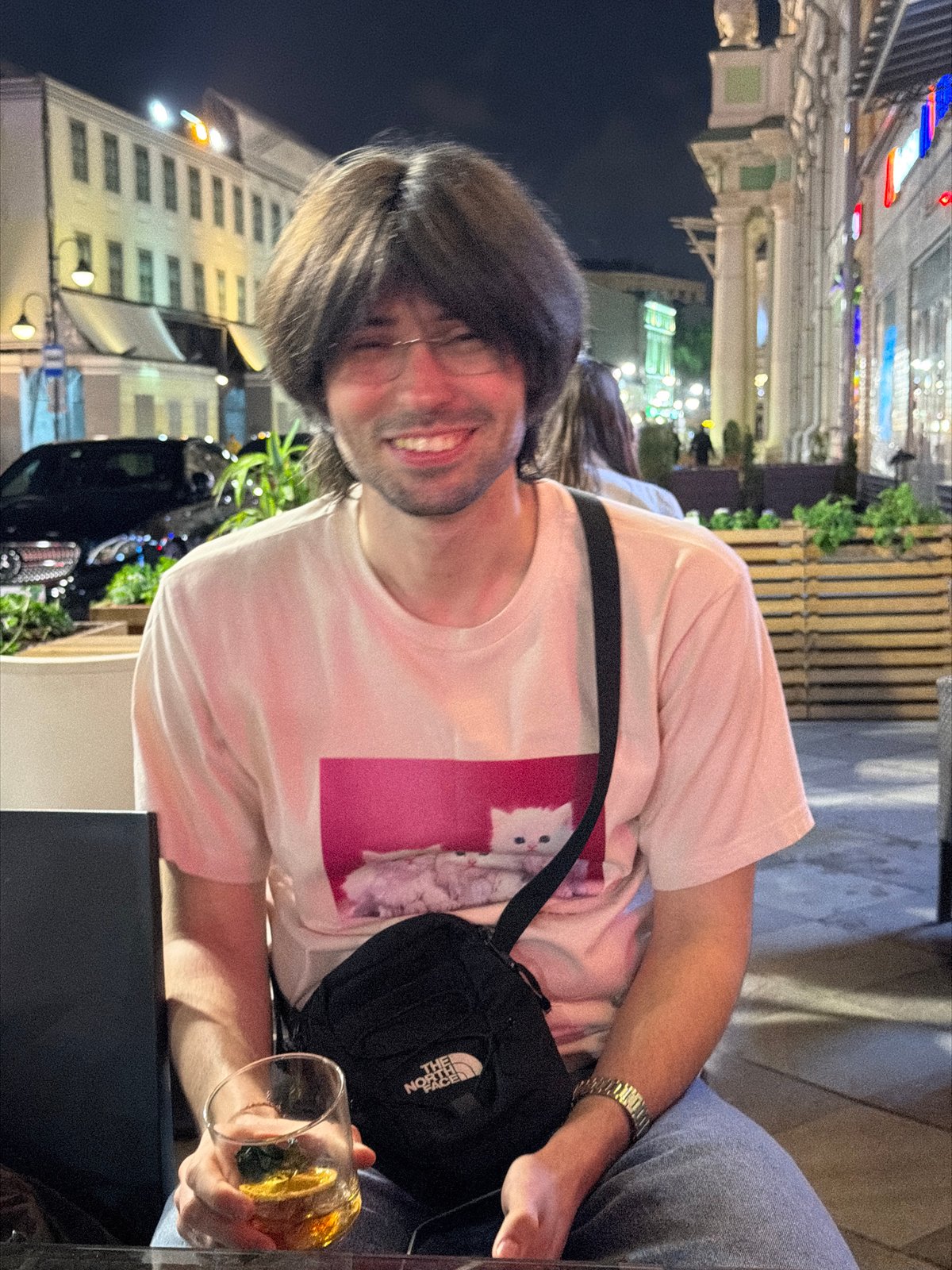 Man with drink spotted smiling in Moscow street scene