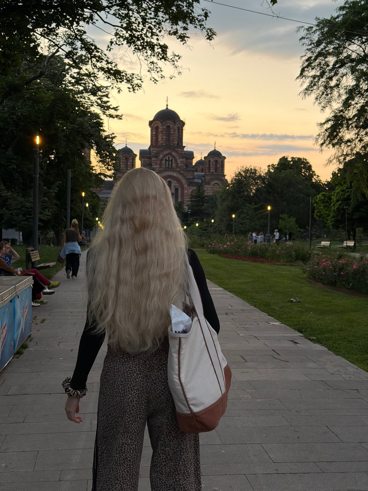 Woman walks near Saint Mark's Church in Belgrade evening