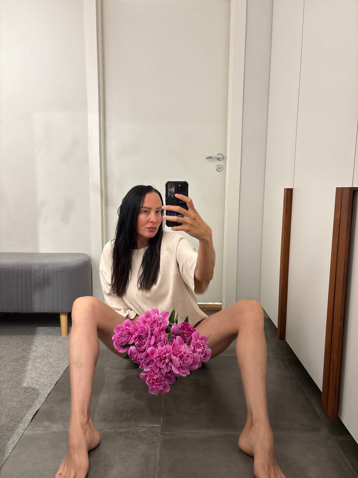 Woman documents peony bouquet gift with selfie session