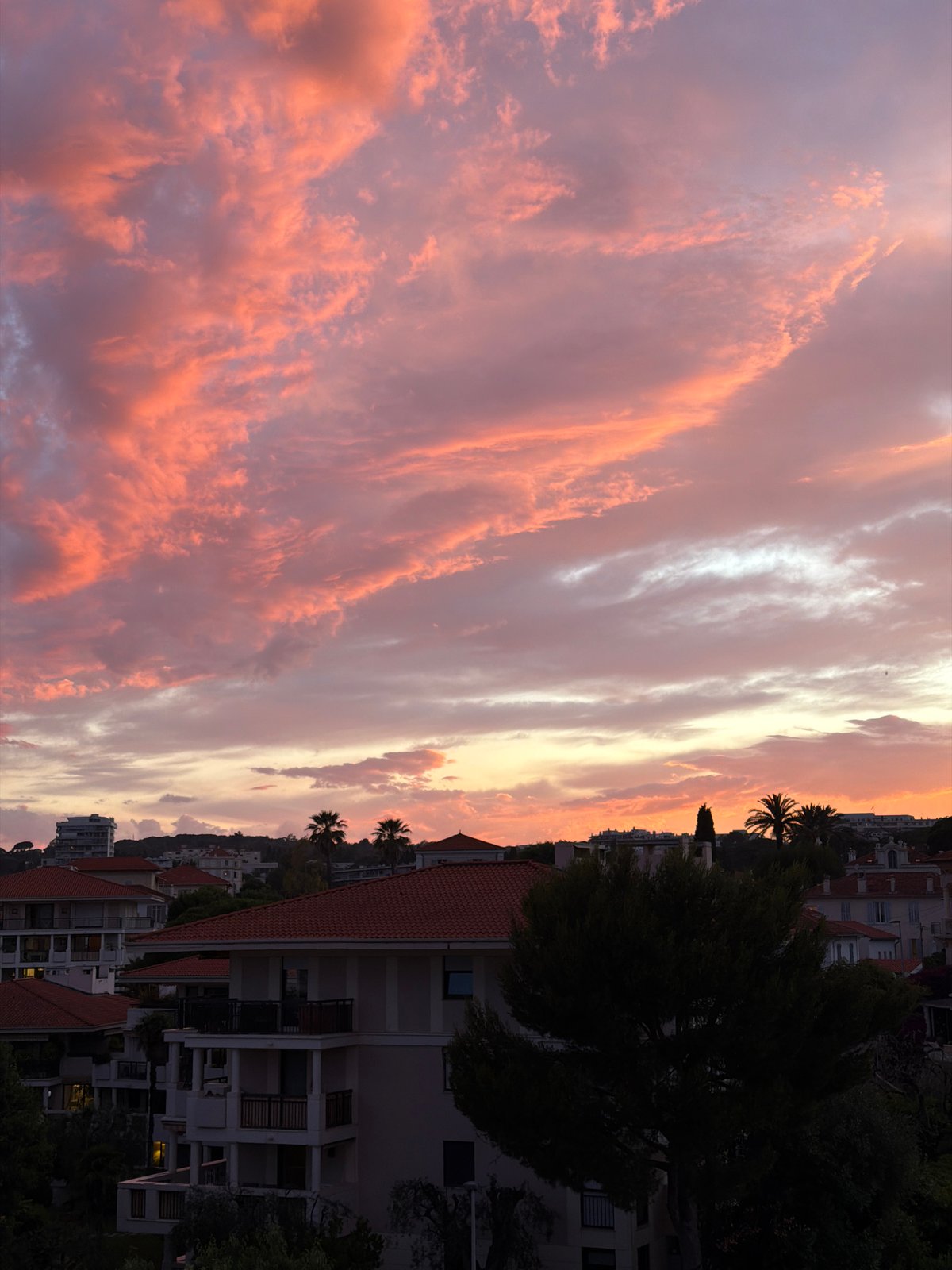 Dramatic sunset illuminates Cannes skyline with vibrant colors