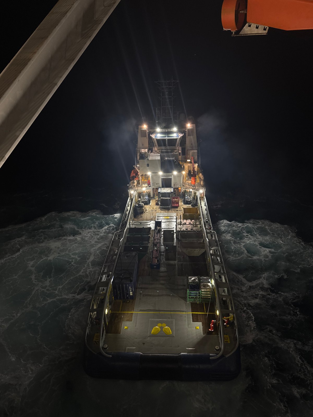 Night drone shot of a loaded supply vessel off Italy