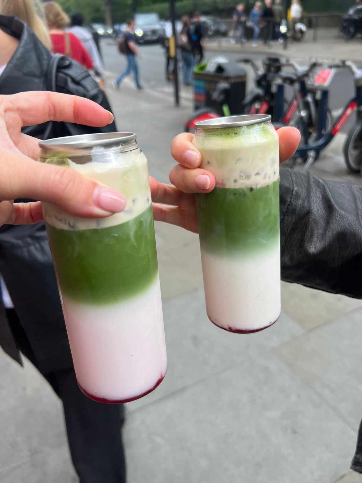 Person holds layered green drinks in London