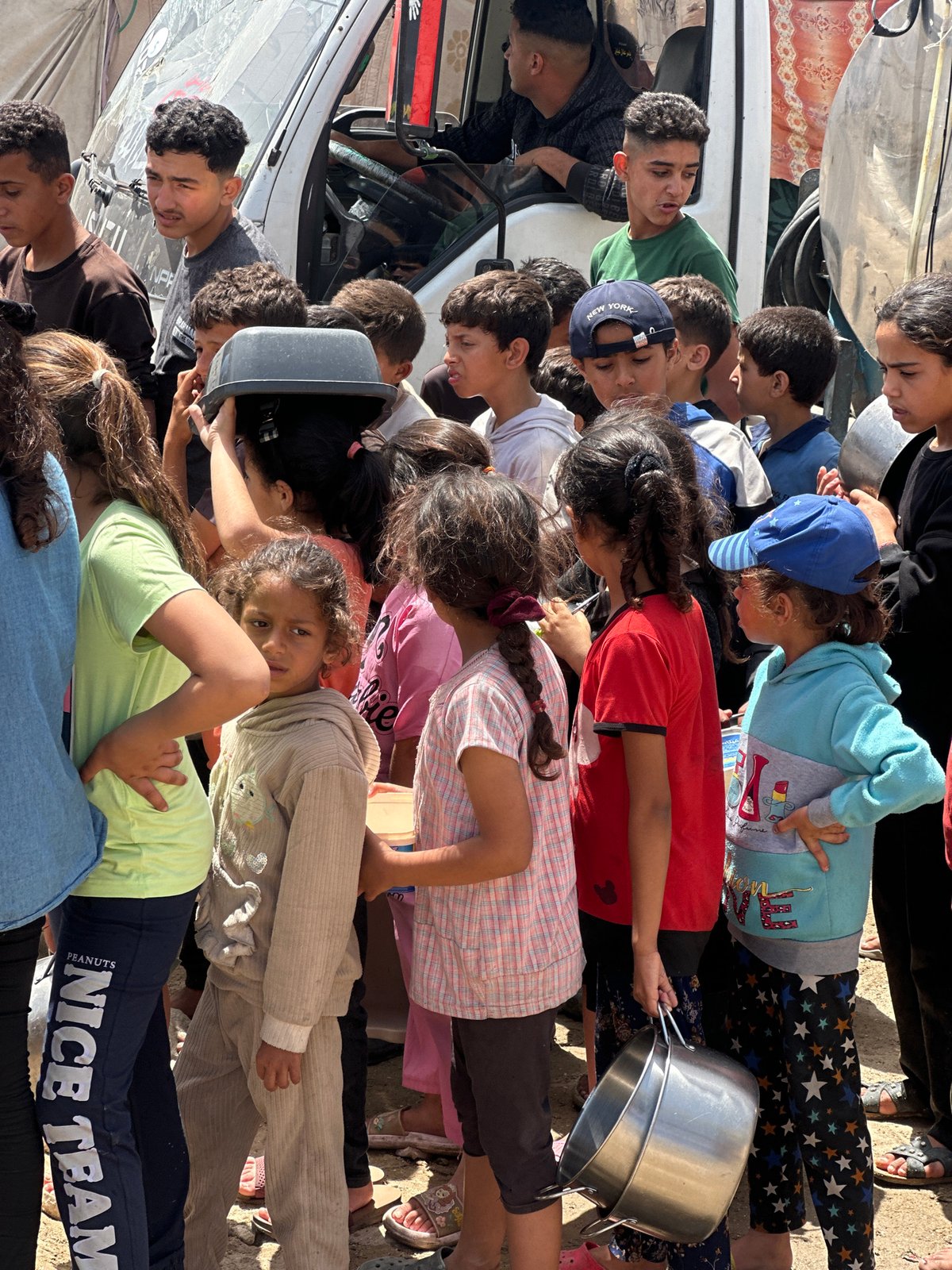 Gaza residents collect aid amid damaged buildings, temporary shelters