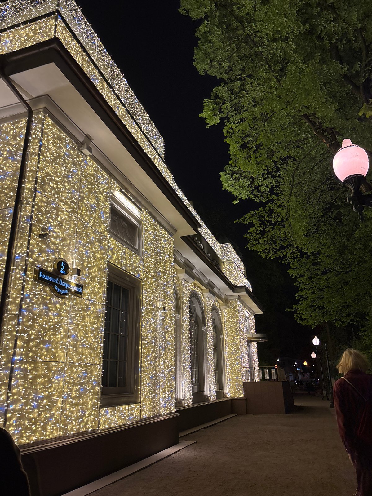 Woman photographed at illuminated building in Moscow evening